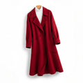 A long double breasted coat with wide lapels and front patch pockets displayed on a hanger._0