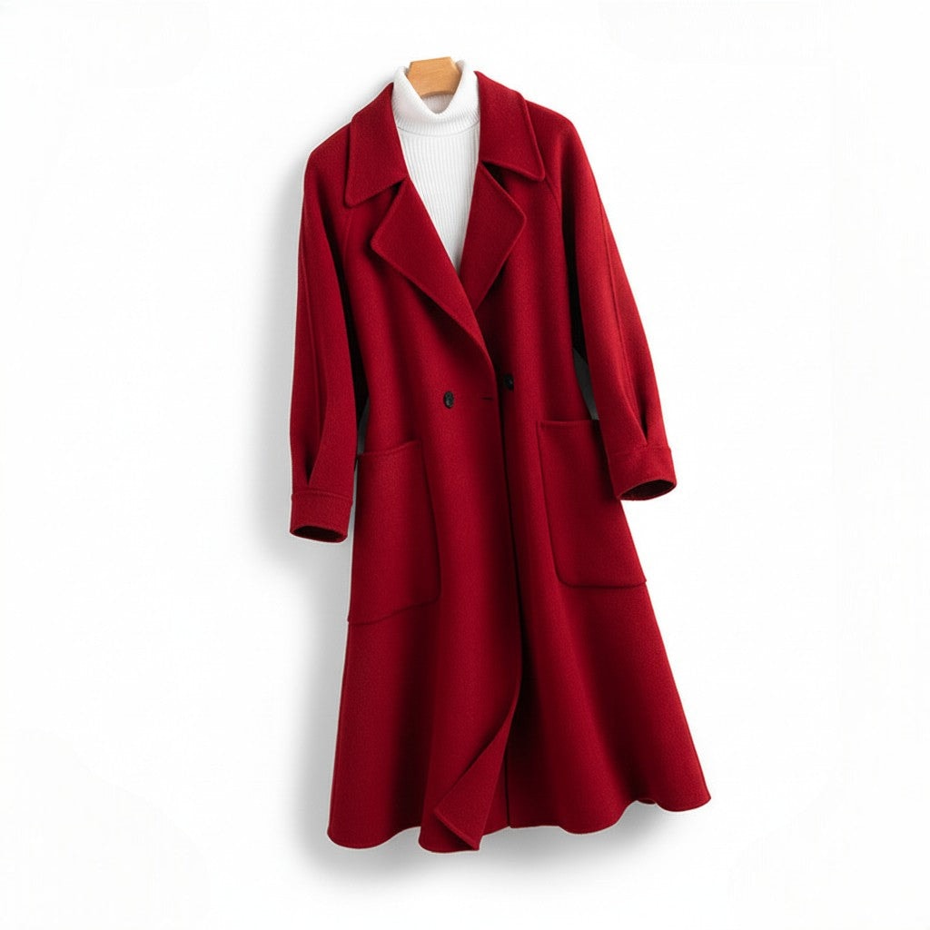 A long double breasted coat with wide lapels and front patch pockets displayed on a hanger._0