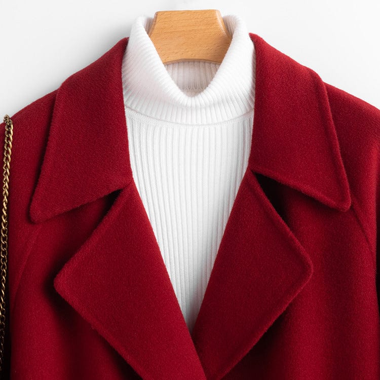 A long double breasted coat with wide lapels and front patch pockets displayed on a hanger._4