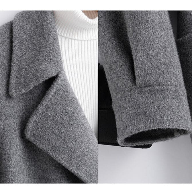 A long double breasted coat with wide lapels and front patch pockets displayed on a hanger._9