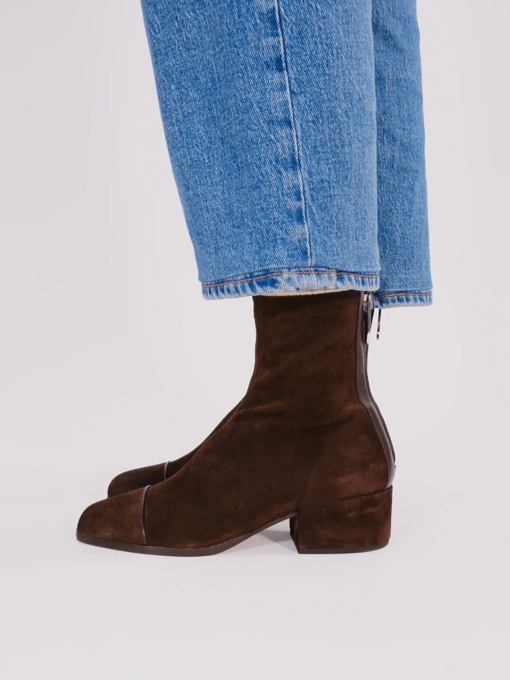 Woman wearing brown ankle boots with block heel and square toe, styled with light blue jeans._4