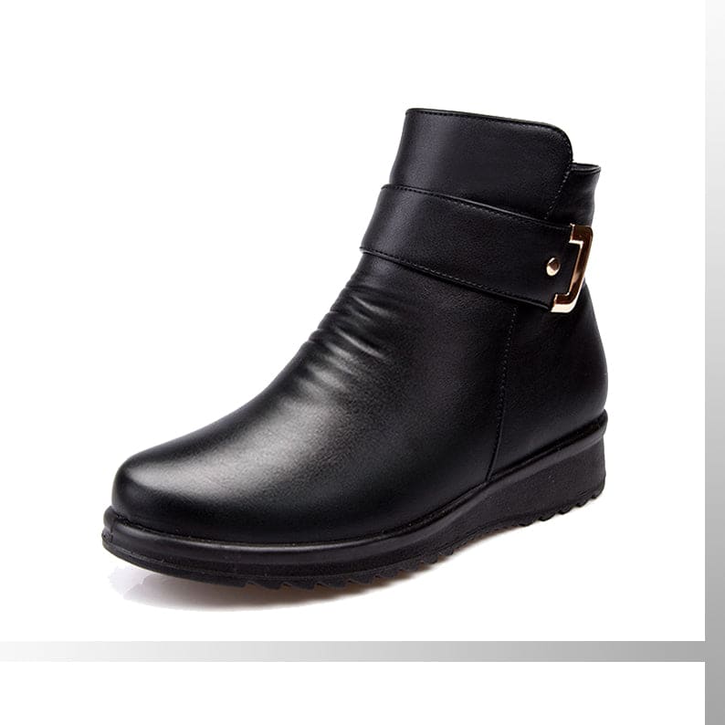 Close-up of a black ankle boot with a buckle strap detail and cushioned sole._0