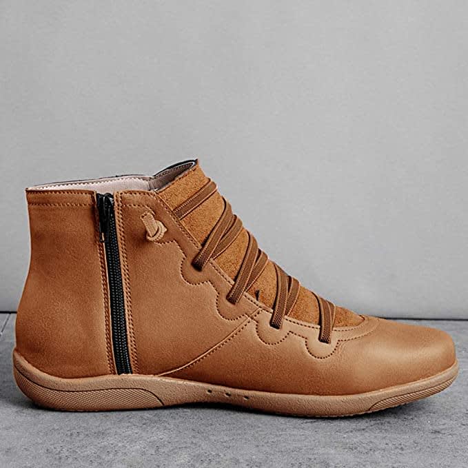 Pair of ankle boots with criss-cross lacing detail and side zipper closure displayed on a neutral background_1