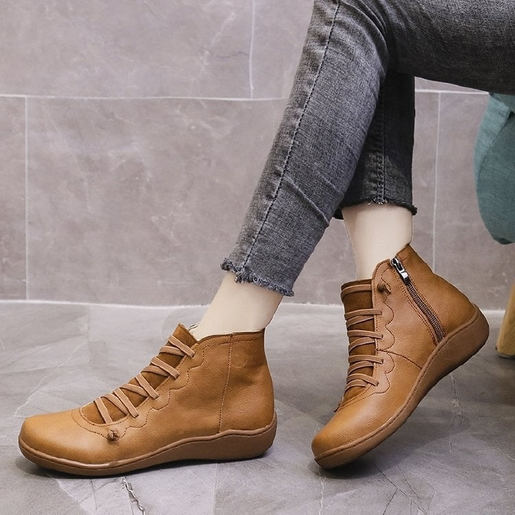 Pair of ankle boots with criss-cross lacing detail and side zipper closure displayed on a neutral background_10