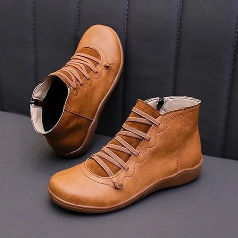 Pair of ankle boots with criss-cross lacing detail and side zipper closure displayed on a neutral background_11