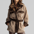 Woman wearing a textured teddy jacket with contrast trim, belted waist, and chest pockets._0