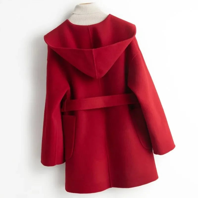 Woman wearing a belted wrap coat with a wide shawl collar, tie belt, and patch pockets over a turtleneck and trousers._20