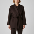 Woman wearing a dark belted wrap jacket with shawl collar and tie waist, styled with matching pants._0