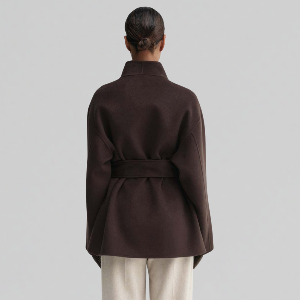 Woman wearing a dark belted wrap jacket with shawl collar and tie waist, styled with matching pants._1