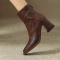 Side view of a block heel ankle boot with clean seam detailing and side zip closure worn on a foot against a neutral background._0