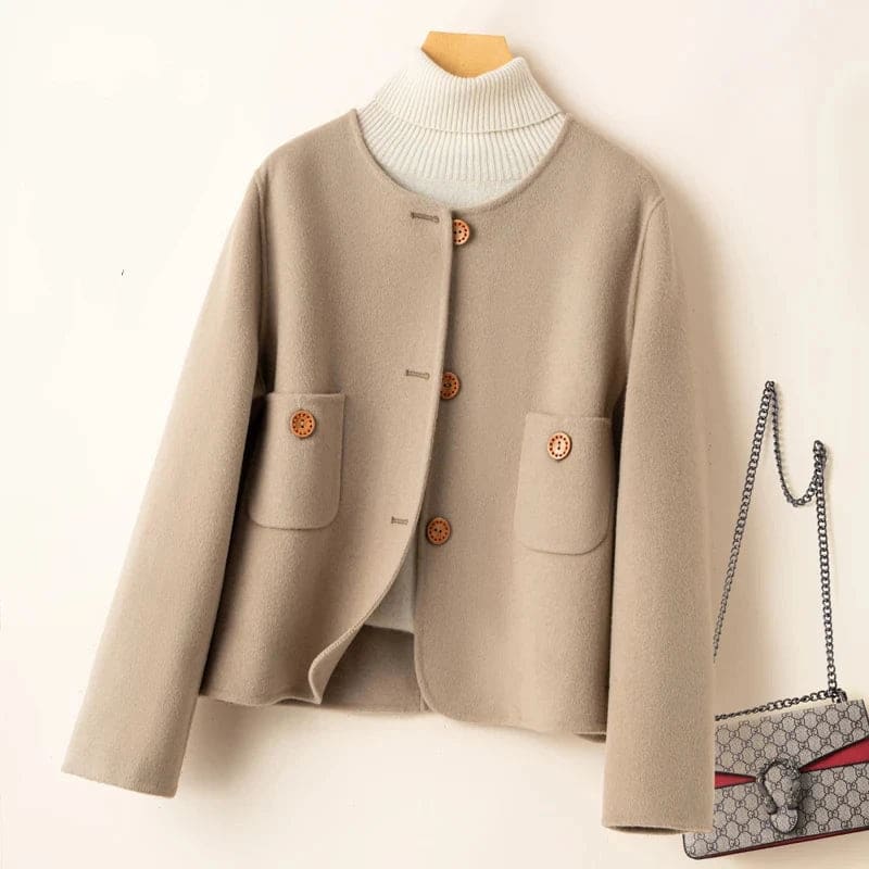 Woman wearing a button-front jacket with round neckline over a turtleneck sweater and beige trousers in natural light_14