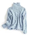 Full view of the pale blue knitted sweater with long sleeves, a high neckline, and flowing vertical cable patterns.
