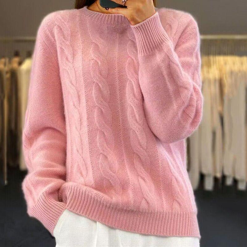 Woman wearing a cable knit jumper in soft pink with ribbed neckline and cuffs, styled with light trousers._0