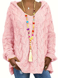 Woman wearing an oversized cable knit hooded sweater styled with jeans and layered necklaces._0