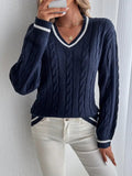Front view of a navy cable-knit sweater with a striped V-neck, long sleeves, and coordinating striped cuffs.