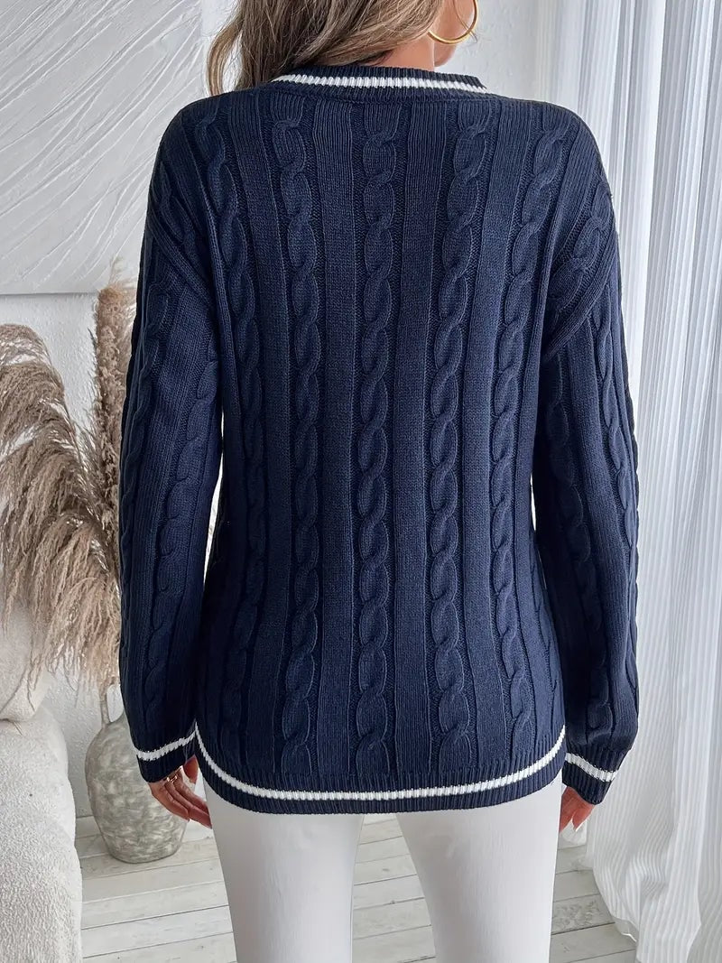 Back view of the navy sweater displaying the full cable-knit texture, long sleeves, and striped hem trim.