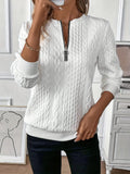 Woman wearing a textured cable knit zip-up sweater with ribbed cuffs and hem, styled with dark pants._0