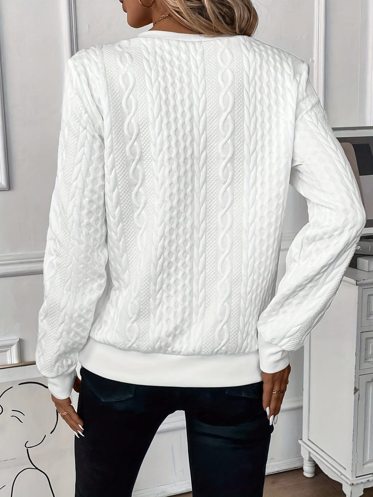 Woman wearing a textured cable knit zip-up sweater with ribbed cuffs and hem, styled with dark pants._1