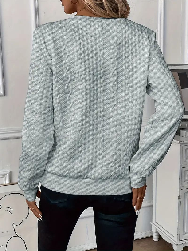 Woman wearing a textured cable knit zip-up sweater with ribbed cuffs and hem, styled with dark pants._7