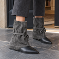 Grey slouched ankle boots with black pointed toes and wrap-around ties, worn with grey wide-leg trousers on a stone pavement._0