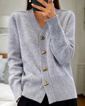 Woman wearing a light grey cardigan with heart-shaped buttons and ribbed detailing at the neckline and cuffs._0