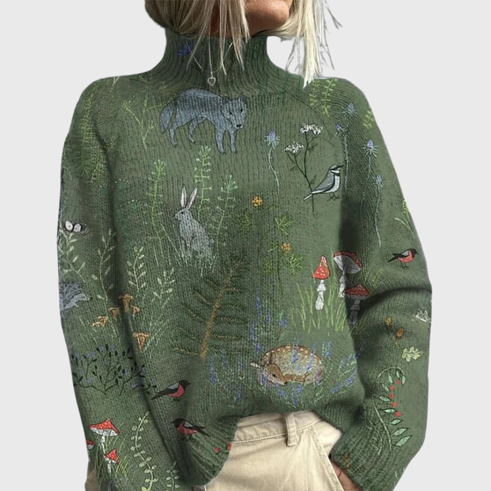 Woman wearing a loose green turtleneck sweater printed with wolves, a hare, birds, mushrooms and plants, paired with beige trousers._0