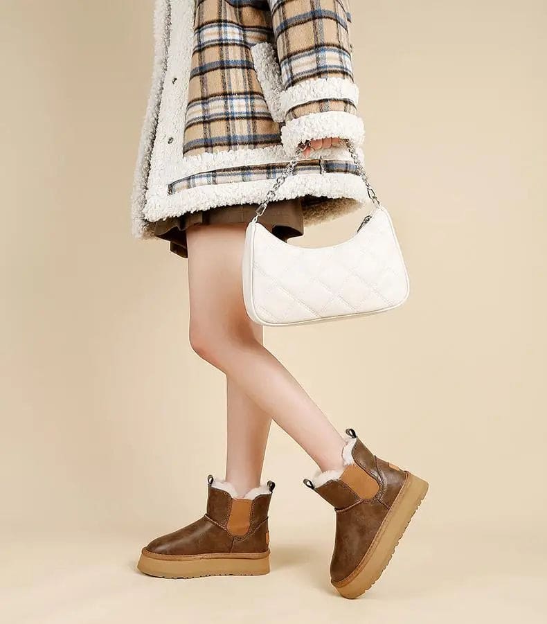 Pair of tan chelsea boots with elastic side panels, chunky platform soles, and soft faux fur lining displayed against a neutral background._13