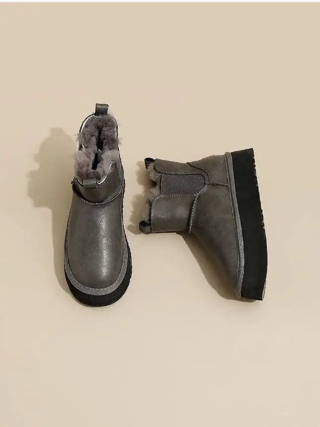 Pair of tan chelsea boots with elastic side panels, chunky platform soles, and soft faux fur lining displayed against a neutral background._14