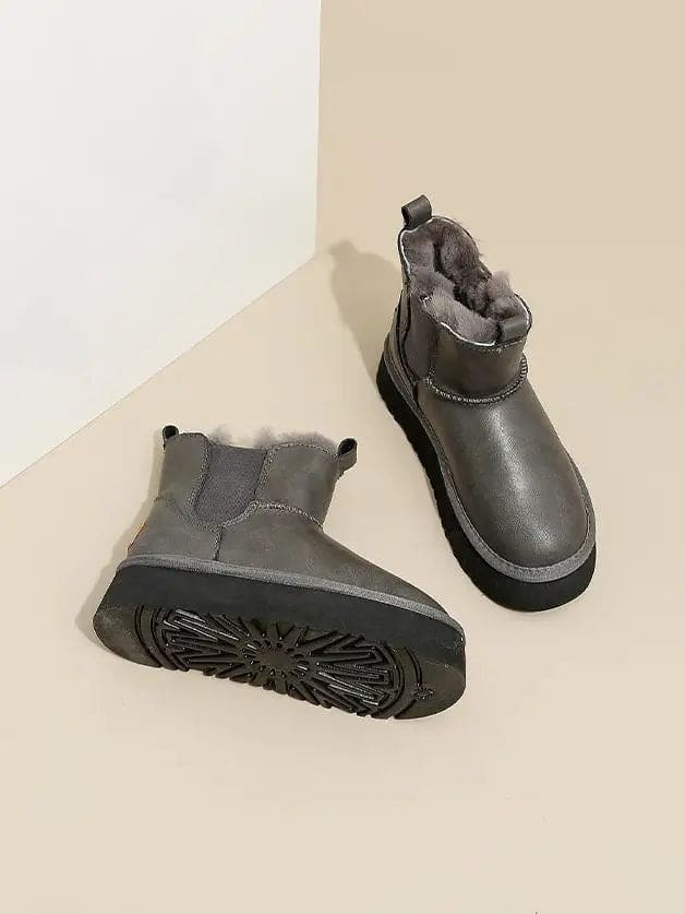Pair of tan chelsea boots with elastic side panels, chunky platform soles, and soft faux fur lining displayed against a neutral background._15