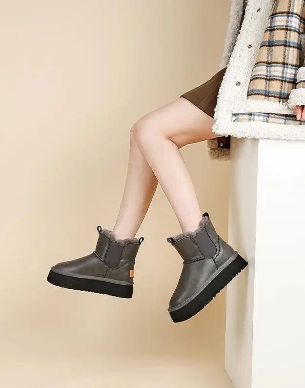 Pair of tan chelsea boots with elastic side panels, chunky platform soles, and soft faux fur lining displayed against a neutral background._18