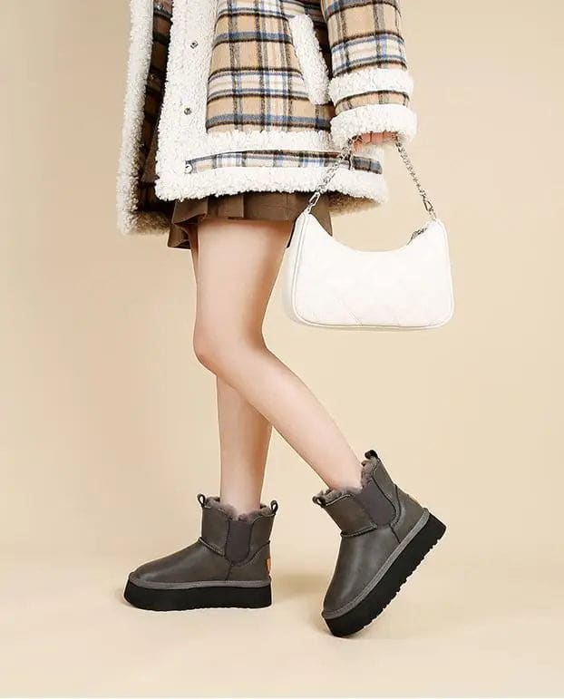 Pair of tan chelsea boots with elastic side panels, chunky platform soles, and soft faux fur lining displayed against a neutral background._19