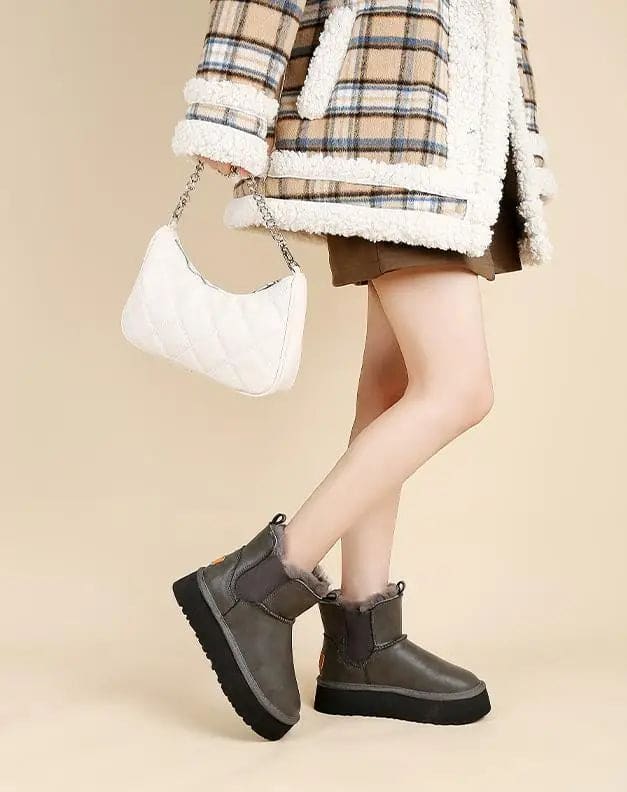 Pair of tan chelsea boots with elastic side panels, chunky platform soles, and soft faux fur lining displayed against a neutral background._20