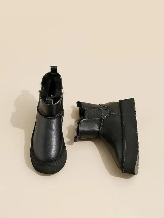 Pair of tan chelsea boots with elastic side panels, chunky platform soles, and soft faux fur lining displayed against a neutral background._21