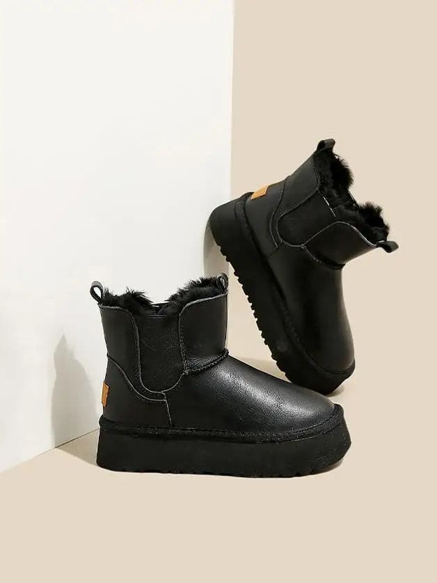 Pair of tan chelsea boots with elastic side panels, chunky platform soles, and soft faux fur lining displayed against a neutral background._22