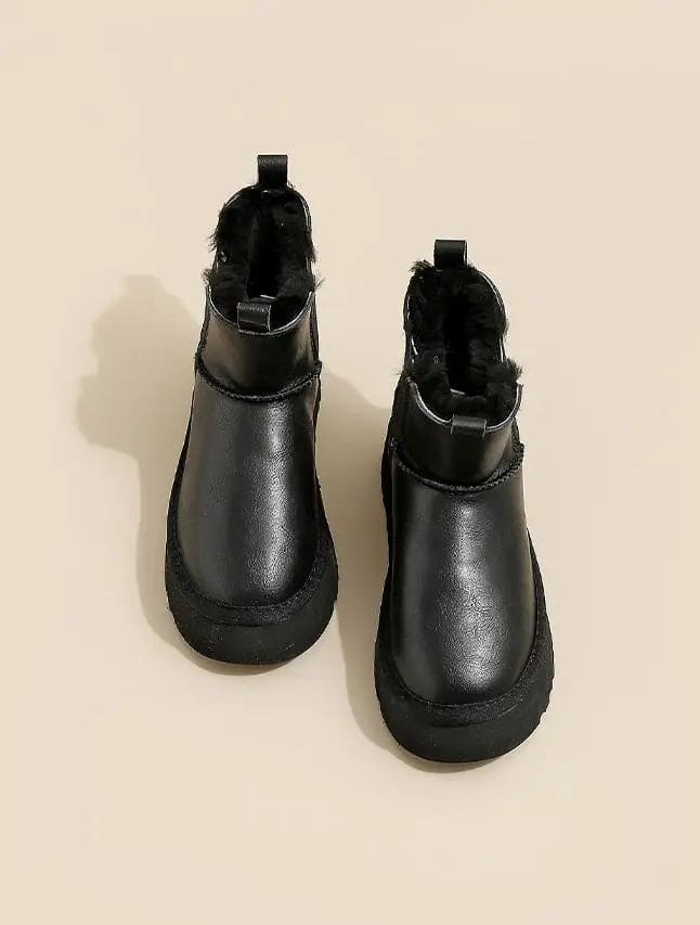 Pair of tan chelsea boots with elastic side panels, chunky platform soles, and soft faux fur lining displayed against a neutral background._23