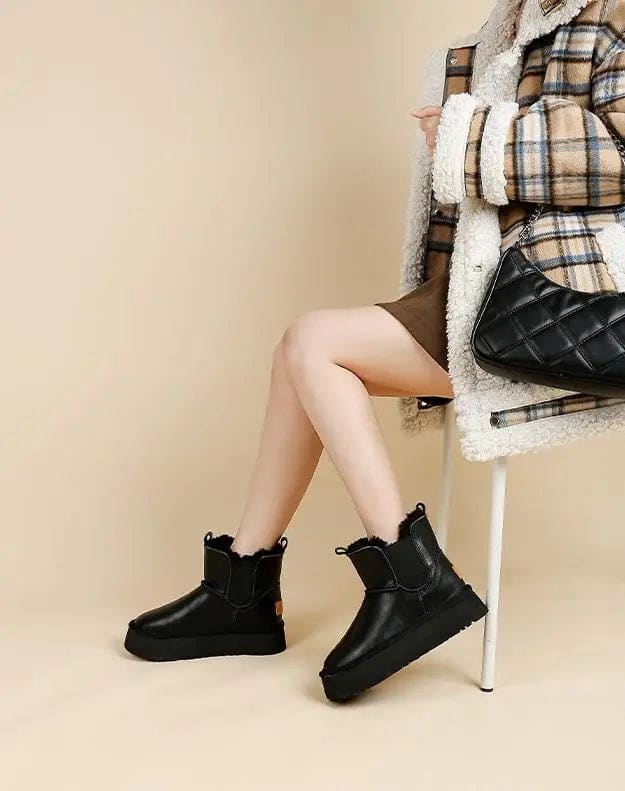 Pair of tan chelsea boots with elastic side panels, chunky platform soles, and soft faux fur lining displayed against a neutral background._25