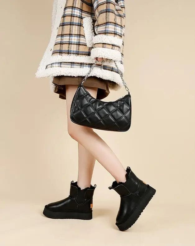 Pair of tan chelsea boots with elastic side panels, chunky platform soles, and soft faux fur lining displayed against a neutral background._26