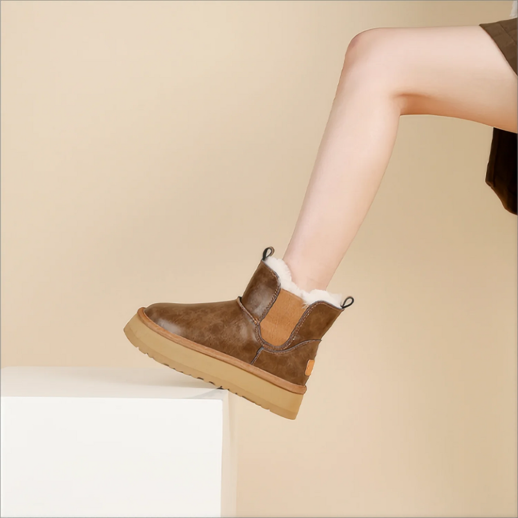 Pair of tan chelsea boots with elastic side panels, chunky platform soles, and soft faux fur lining displayed against a neutral background._3