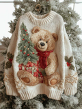Cream-colored Christmas sweater with a raised teddy bear holding gifts and a decorated tree, featuring ribbed neckline and cuffs, displayed on a stand against a snowy background._0