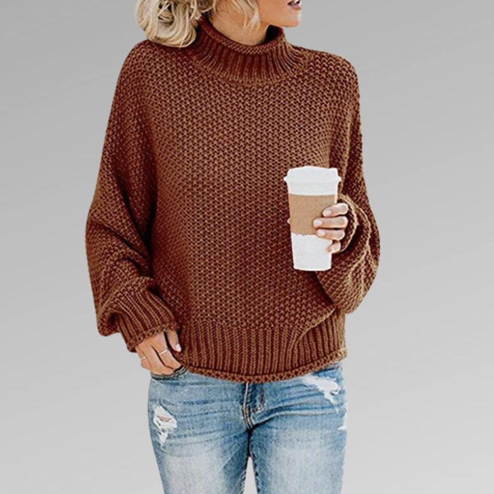 Brown chunky knit turtleneck sweater with a cozy textured pattern and ribbed hem, paired with casual distressed denim.