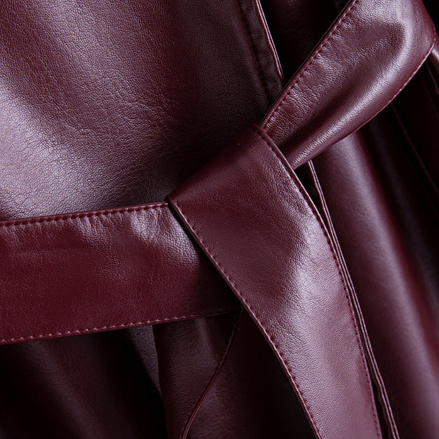 A long burgundy wrap coat with an asymmetric buttoned neckline, waist tie belt, and side welt pockets displayed on a hanger._8