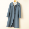 A mid length button front coat with a pointed collar, long sleeves, and side welt pockets shown on a hanger._0