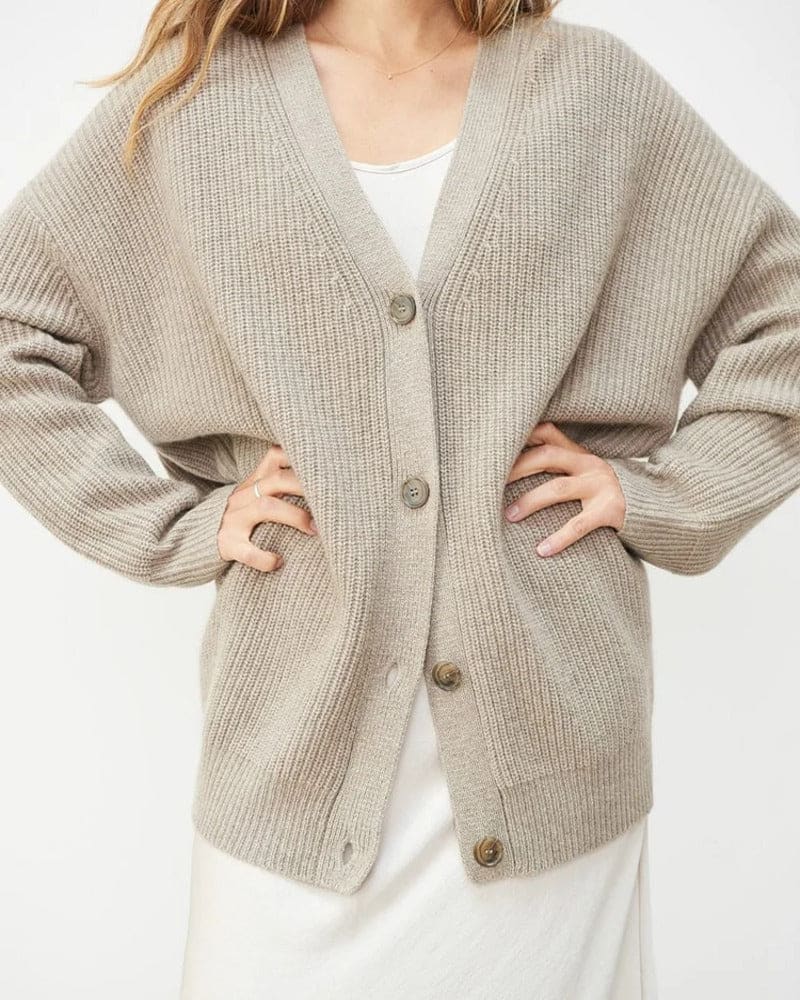 Woman wearing an oversized ribbed cardigan with button-front closure and relaxed cocoon fit, styled with neutral pants._1