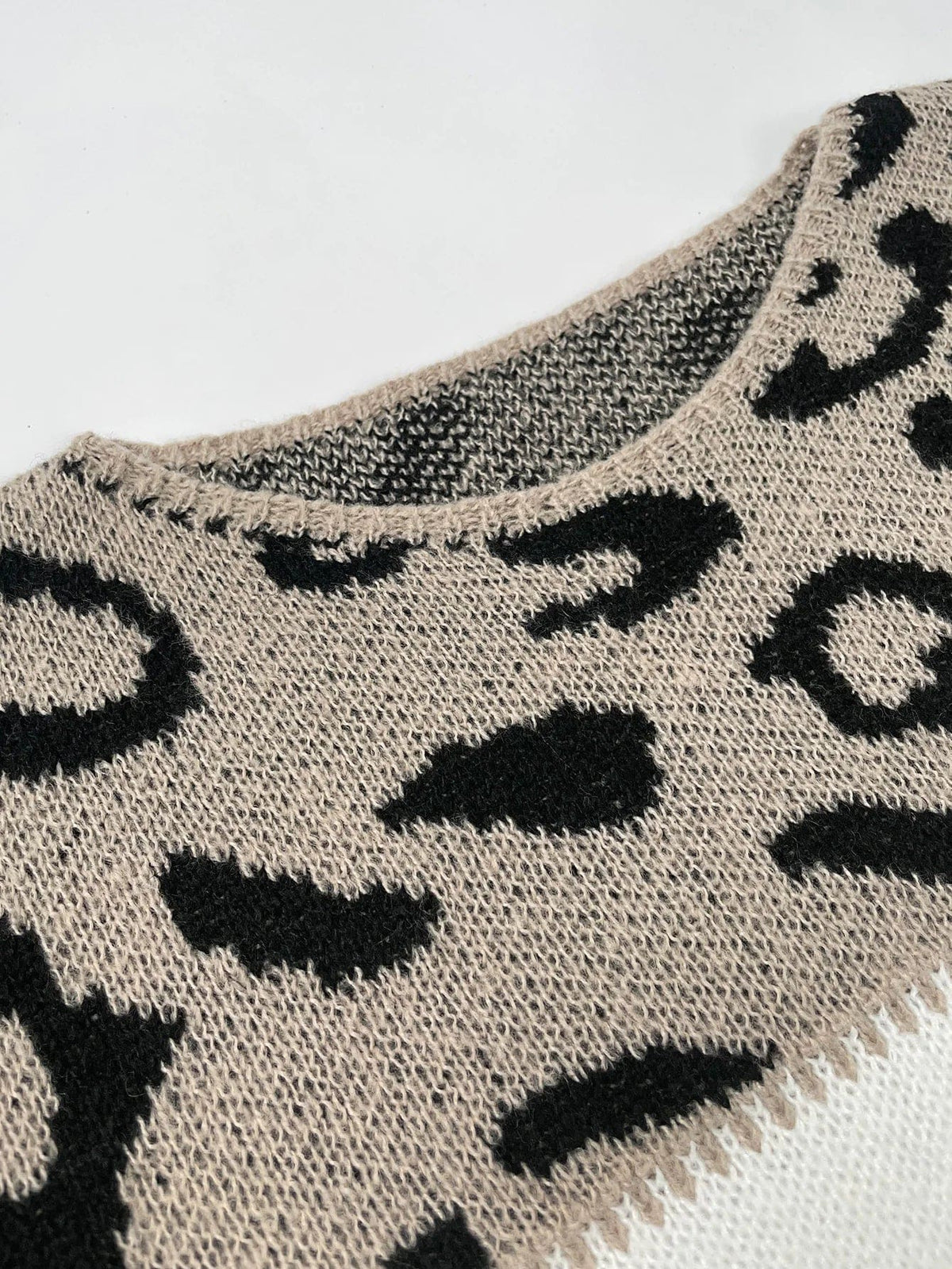 Woman wearing a color block sweater with leopard print shoulders and solid grey and white body panels._1