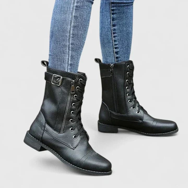 Woman wearing black mid-calf combat boots with lace-up front and side zipper, paired with light blue skinny jeans._0