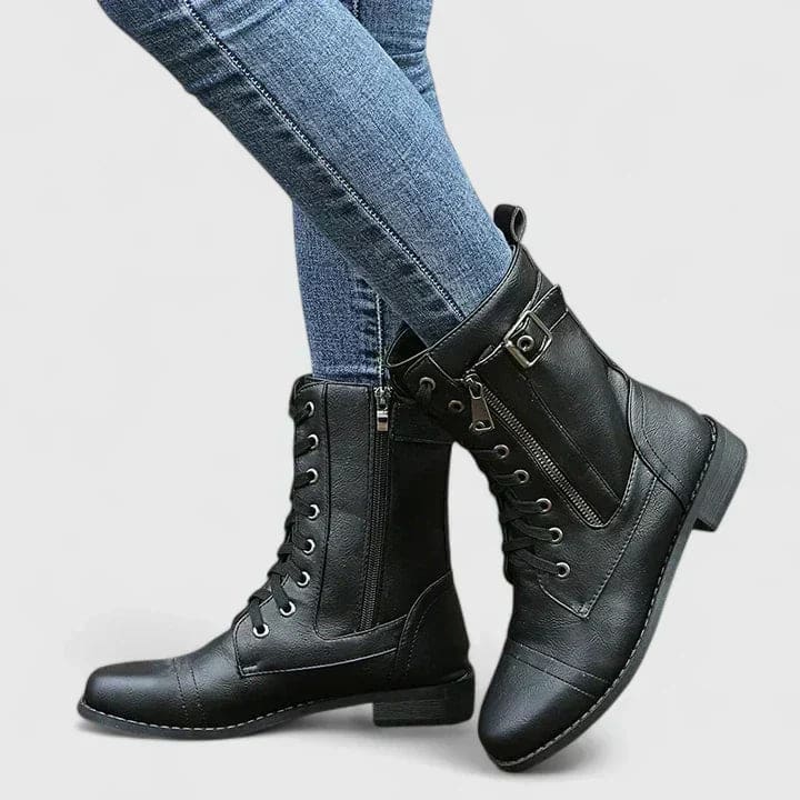 Woman wearing black mid-calf combat boots with lace-up front and side zipper, paired with light blue skinny jeans._1