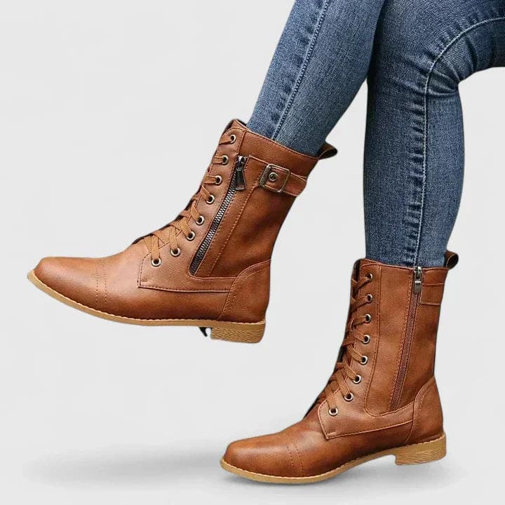 Woman wearing black mid-calf combat boots with lace-up front and side zipper, paired with light blue skinny jeans._2
