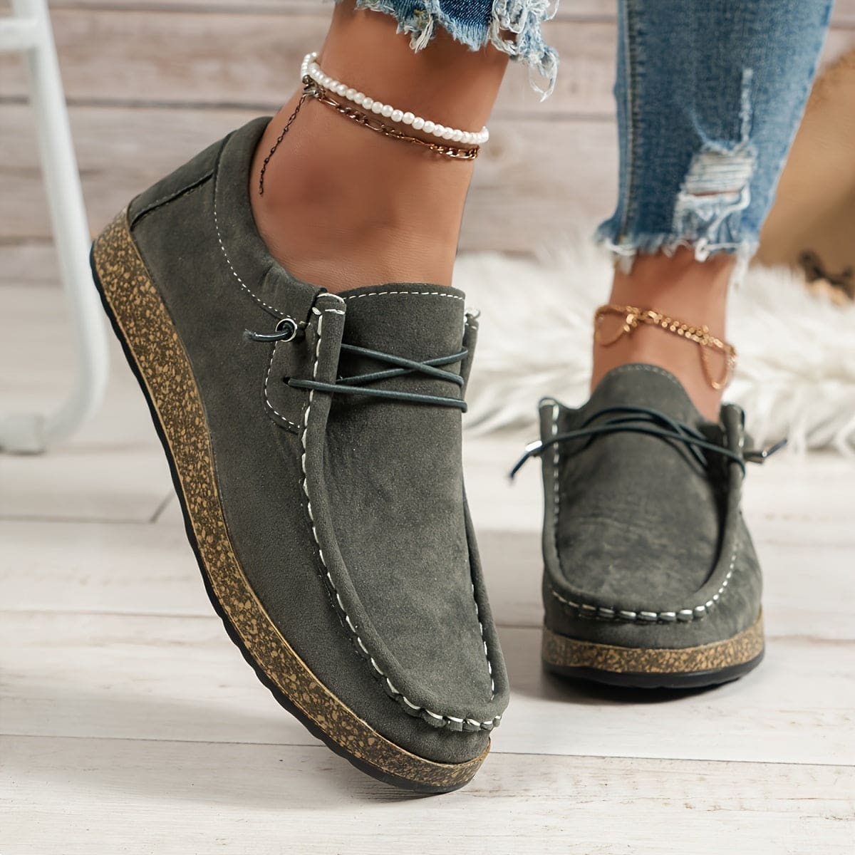 Woman wearing platform loafers with lace-up detail, cork-effect sole, and distressed denim shorts with chain anklet._5