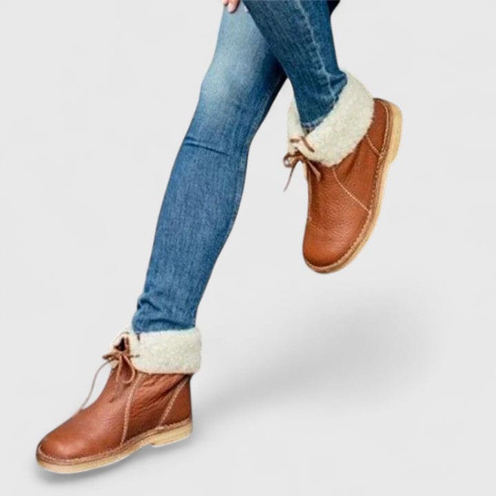 Woman wearing ankle boots with faux fur cuff and lace-up front, styled with jeans._0