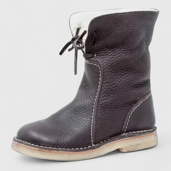 Woman wearing ankle boots with faux fur cuff and lace-up front, styled with jeans._1